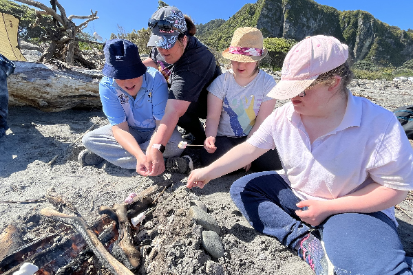 students building a fire on the beach