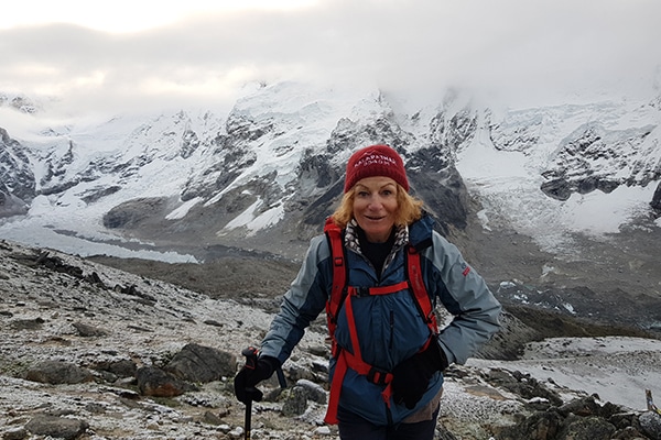 woman in an alpine environment with glacier and snowcapped mountains behind her